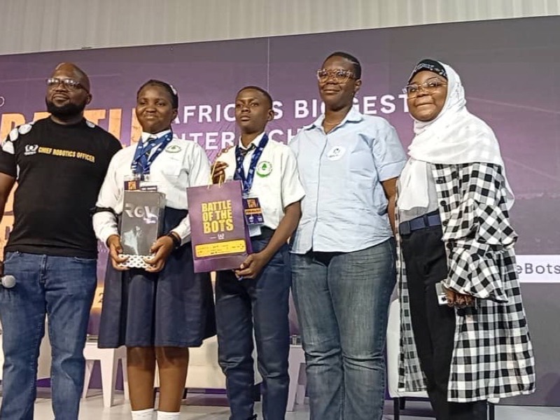 Students holding their trophy and certificate at the Battle of the Bots robotics competition